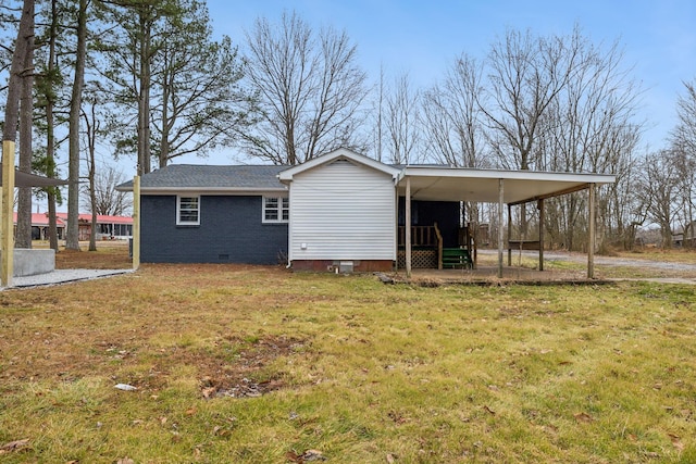 rear view of house featuring a carport and a lawn