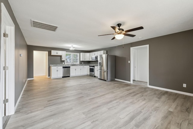 kitchen featuring sink, white cabinetry, appliances with stainless steel finishes, ceiling fan, and light hardwood / wood-style floors