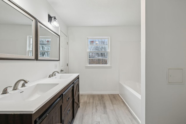 bathroom featuring hardwood / wood-style flooring, vanity, and a bath