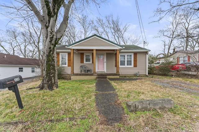 bungalow-style home with covered porch and a front lawn