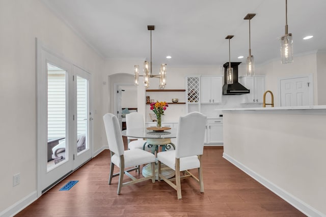 dining room with ornamental molding and hardwood / wood-style floors