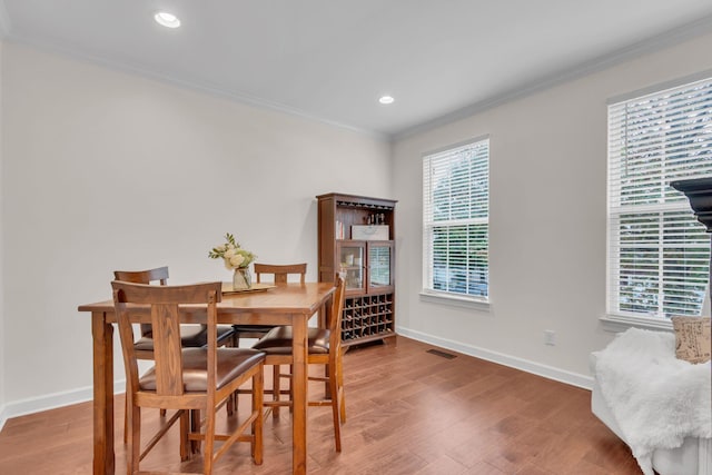 dining room with crown molding and hardwood / wood-style floors