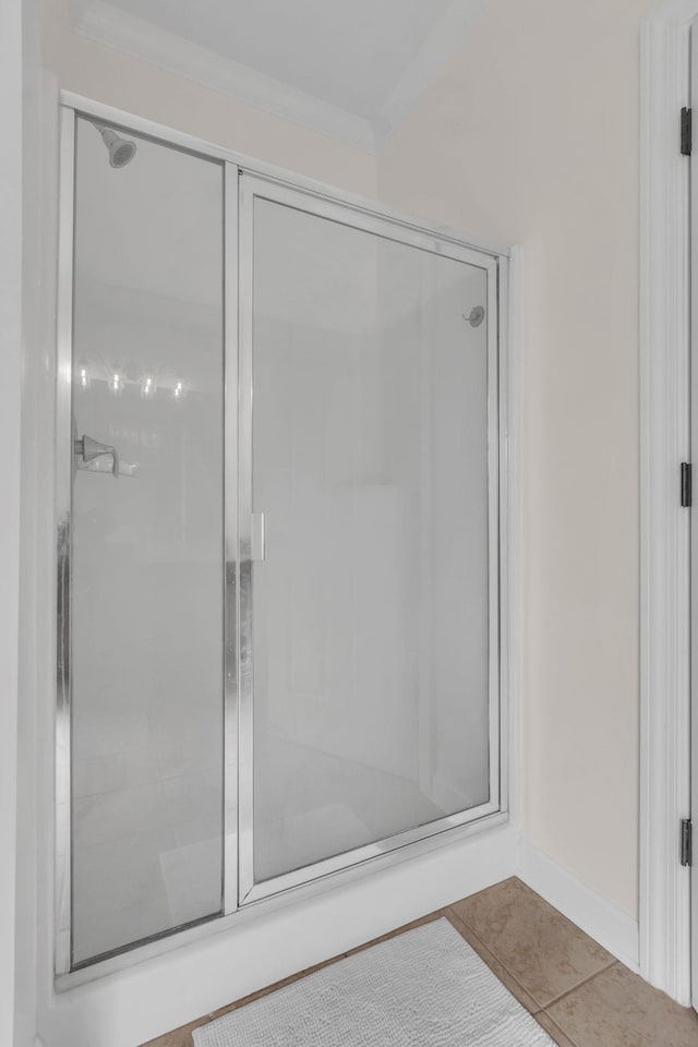 bathroom featuring an enclosed shower, ornamental molding, and tile patterned floors