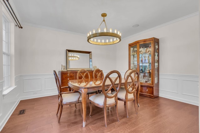 dining area featuring ornamental molding, dark hardwood / wood-style floors, and a chandelier