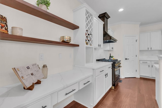 kitchen with dark wood-type flooring, white cabinetry, crown molding, light stone counters, and gas range oven