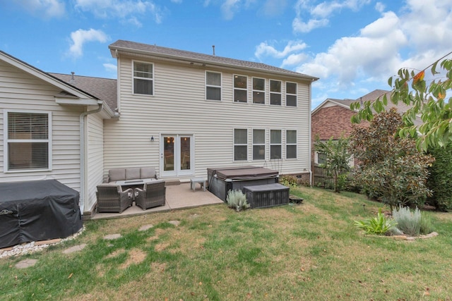 rear view of house with an outdoor living space, a yard, a hot tub, and a patio