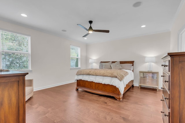 bedroom with ceiling fan, ornamental molding, and wood-type flooring