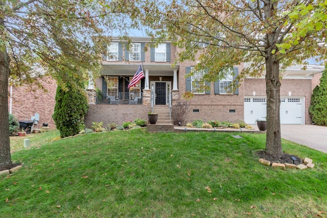 view of front of property featuring a garage, a front yard, and covered porch