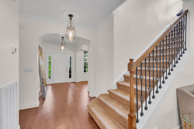 foyer featuring ornamental molding and dark hardwood / wood-style flooring