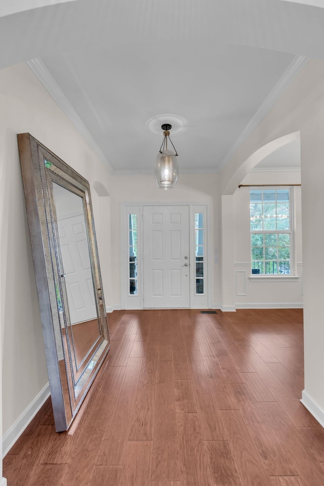 foyer featuring wood-type flooring and crown molding