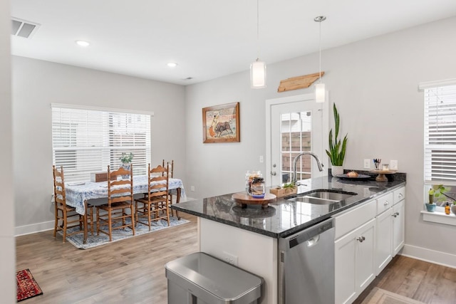 kitchen with sink, white cabinetry, decorative light fixtures, dark stone countertops, and dishwasher