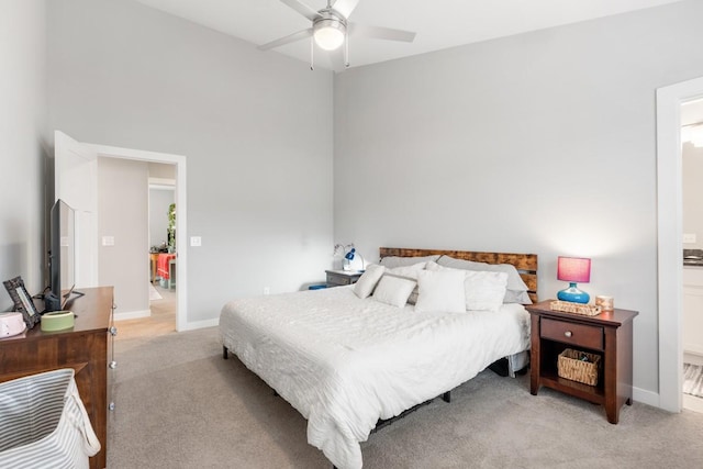 carpeted bedroom with ensuite bath and ceiling fan