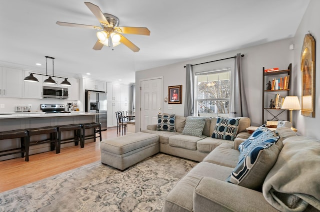 living room featuring ceiling fan and light hardwood / wood-style floors