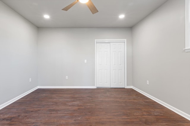 unfurnished bedroom featuring dark hardwood / wood-style floors, ceiling fan, and a closet