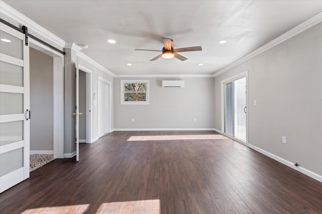 spare room featuring a barn door, ornamental molding, an AC wall unit, and dark wood-type flooring