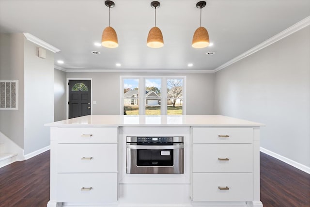 kitchen with white cabinetry, stainless steel oven, and hanging light fixtures