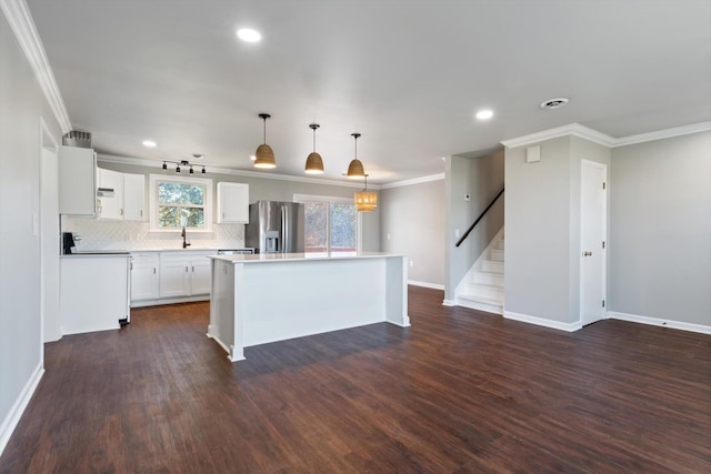 kitchen with white cabinetry, stainless steel fridge with ice dispenser, hanging light fixtures, a kitchen island, and stove