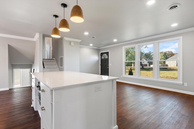 kitchen featuring white cabinetry, crown molding, hanging light fixtures, dark hardwood / wood-style flooring, and a kitchen island