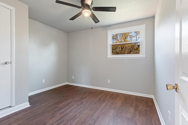 empty room with dark wood-type flooring and ceiling fan