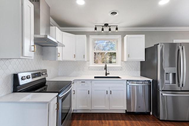 kitchen featuring white cabinets, stainless steel appliances, sink, and wall chimney range hood