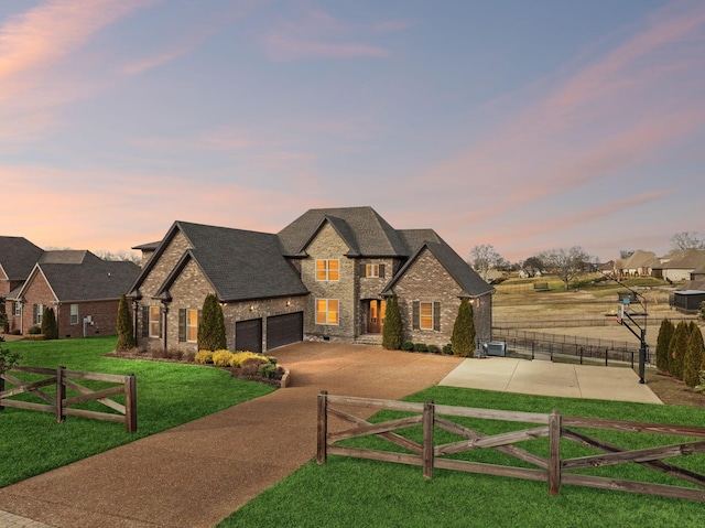 view of front of home with a yard and a garage