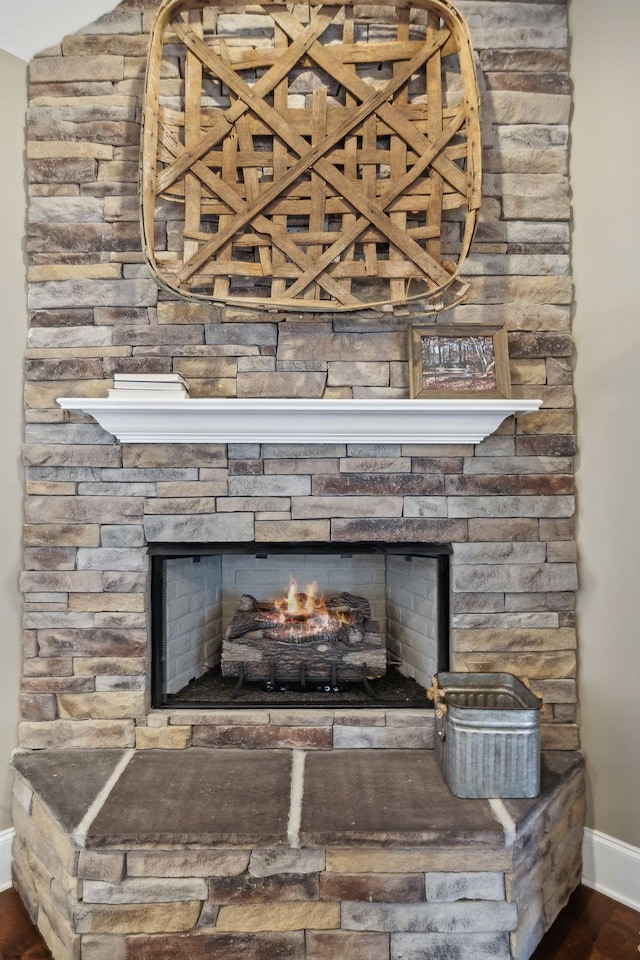 details featuring hardwood / wood-style flooring and a stone fireplace