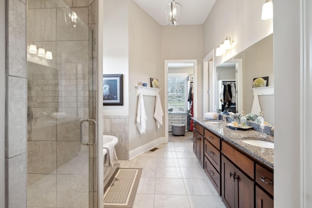 bathroom featuring tile patterned flooring, vanity, and walk in shower