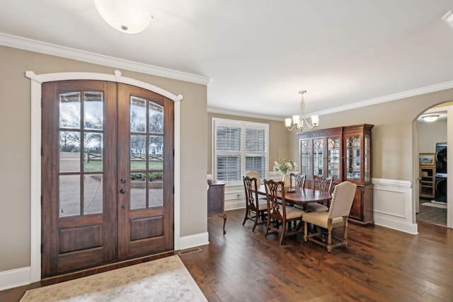 foyer with french doors, a healthy amount of sunlight, dark wood-type flooring, and a notable chandelier