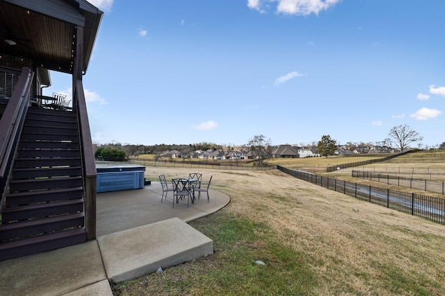 view of yard with a hot tub, a patio, and a rural view