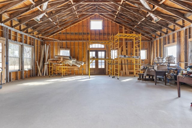 misc room featuring concrete flooring, a wealth of natural light, and high vaulted ceiling