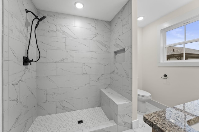 bathroom featuring toilet and a tile shower