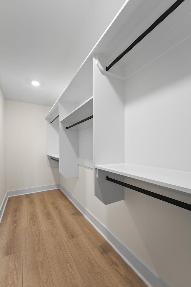 walk in closet with light hardwood / wood-style floors