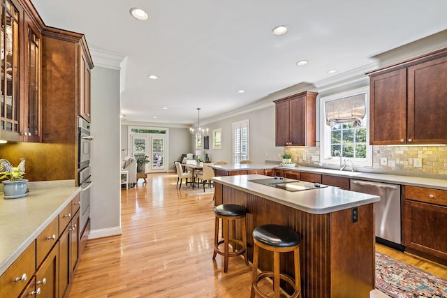 kitchen with backsplash, ornamental molding, a breakfast bar, and appliances with stainless steel finishes