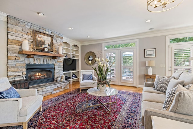 living room with hardwood / wood-style flooring, ornamental molding, and a fireplace