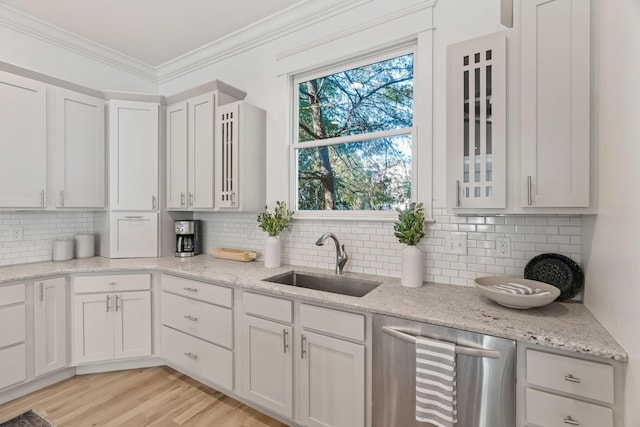 kitchen featuring sink, crown molding, stainless steel dishwasher, light hardwood / wood-style floors, and white cabinets