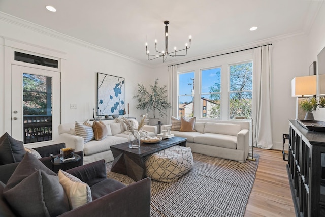 living room with ornamental molding, a chandelier, and light hardwood / wood-style floors