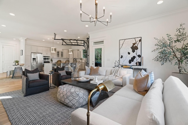 living room with crown molding, hardwood / wood-style floors, and a notable chandelier