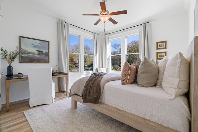 bedroom featuring ornamental molding, light hardwood / wood-style floors, and ceiling fan