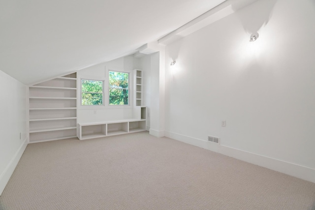 bonus room featuring lofted ceiling, built in features, and carpet