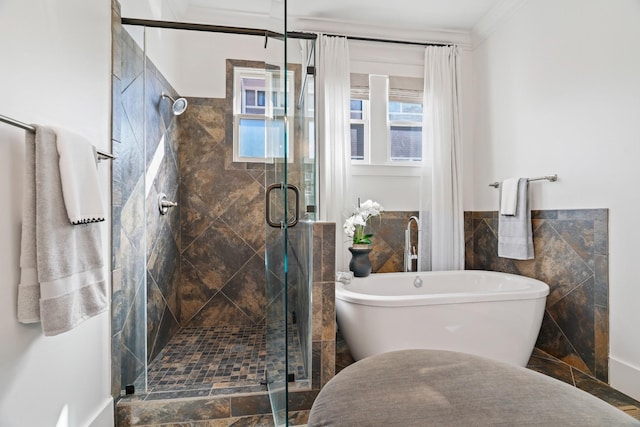 bathroom featuring independent shower and bath, ornamental molding, and tile walls