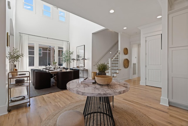 entrance foyer with crown molding and light hardwood / wood-style floors