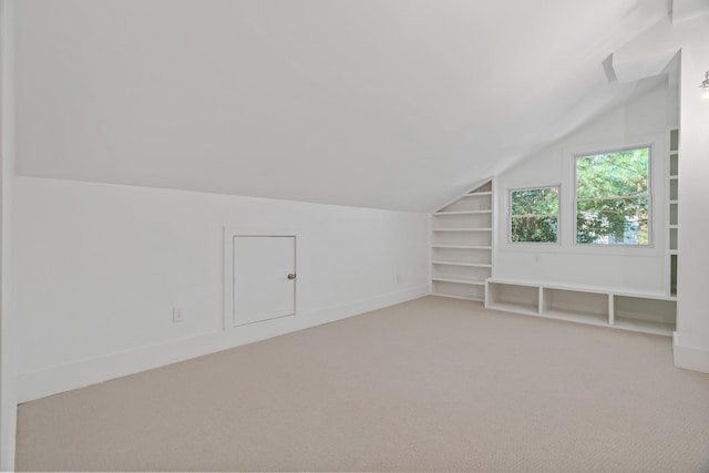 bonus room with lofted ceiling, carpet, and built in shelves