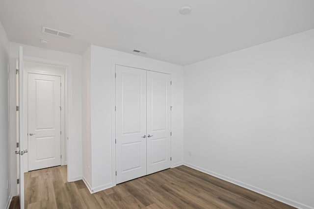 unfurnished bedroom featuring wood-type flooring and a closet