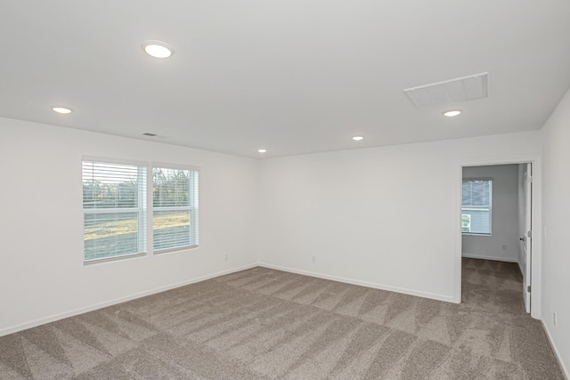 spare room with plenty of natural light and light carpet