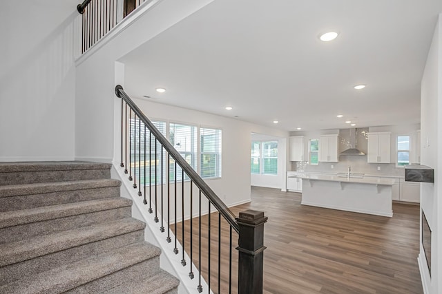 stairs with hardwood / wood-style floors and sink