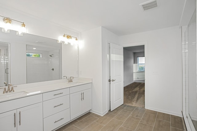 bathroom featuring a shower with door and vanity