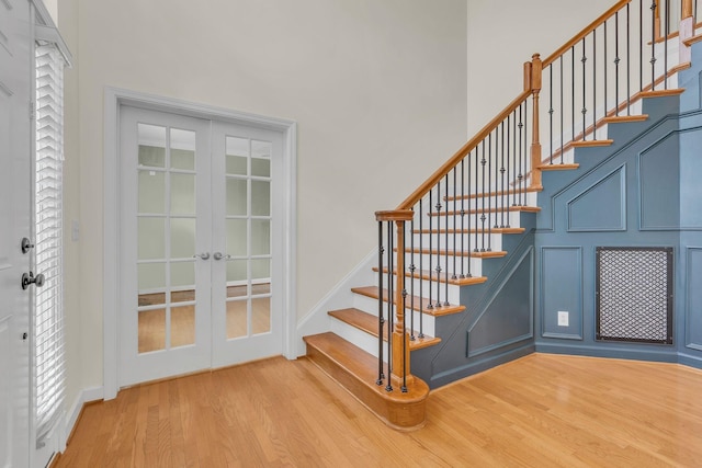 staircase with french doors and wood-type flooring