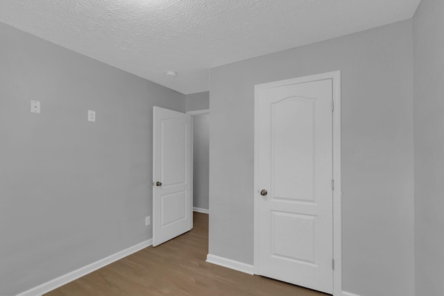 unfurnished bedroom featuring a textured ceiling and light wood-type flooring