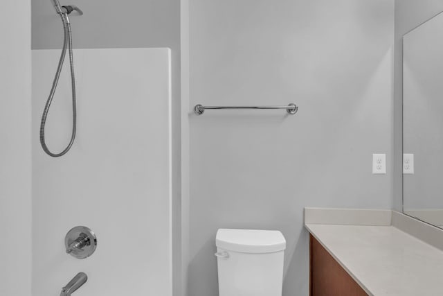 full bathroom featuring washtub / shower combination, vanity, and toilet