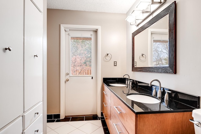 bathroom featuring vanity, tile patterned flooring, and a textured ceiling